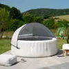 An inflatable hot tub with a canopy is set up on a patio in a backyard, with a lush green landscape and rolling hills in the background. Náhled obrázku produktu