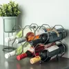A wine rack holding six bottles of wine, with a potted plant in the background. Náhled obrázku produktu