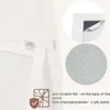 Close-up of a white mirror frame with details about its features, including anti-scratch foil on the back. Náhľad obrázku produktu