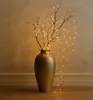 A decorative vase with branches and lights. Produktbild-Vorschau