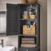 A dark gray bathroom cabinet with its door open, showing shelves with various items like jars, a basket, and folded towels. Náhľad obrázku produktu