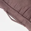 A close-up of a brown cushion with a fabric handle. Náhled obrázku produktu