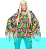 A woman wearing a colorful tie-dye poncho and a headband, posing for a product photo. Produktbild-Vorschau