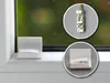 Close-up shots of white mounting plates with a green cord, shown on a windowsill. Produktbild-Vorschau