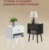 Two nightstands, one white and one black, are displayed against a light brown background. The white nightstand has a plant and a glass on top, while the black nightstand has a lamp and books. Text is present at the top of the image. Produktbild-Vorschau