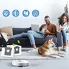 A couple relaxing on a couch with a dog, while a robot vacuum cleaner operates in the foreground. Produktbild-Vorschau