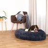 A dog is resting in a plush dog bed next to a chair and a small table with a plant. Anteprima dell’immagine prodotto