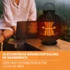 A person is sitting at a table outdoors with a laptop and a heater. Anteprima dell’immagine prodotto