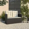A dark brown poly rattan garden bench with beige cushions sits on a gravel patio next to a house. Náhľad obrázku produktu