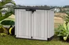 A storage box is placed on a grassy area next to some plants, with a blurred background of buildings and sky. Náhled obrázku produktu