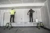 Two construction workers are working on a wall using a telescopic plank. Produktbild-Vorschau