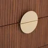 A close-up of a wooden dresser drawer with a gold circular handle. Podgląd zdjęcia produktu