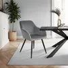 A modern dining room setting with a gray velvet chair and a black dining table. Produktbild-Vorschau