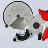 A close-up view of a pipe cutter with a small piece of pipe being cut. Produktbild-Vorschau