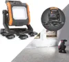 A collage of images showing a portable LED work light and its accessories, as well as the light in use in a construction setting. Produktbild-Vorschau