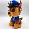 A plush toy dog wearing a police uniform and hat, sitting against a white background. Voir les images du produit