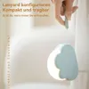 A hand holding a cloud-shaped LED night light with a lanyard. Produktbild-Vorschau
