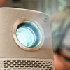 A close-up shot of a projector lens emitting a bright blue light. Produktbild-Vorschau