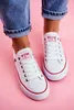 A pair of white Big Star sneakers with red trim, worn by a person with blue jeans and a gold anklet, against a pink background. Voir les images du produit