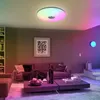 A modern living room with a ceiling light that changes colors, a sofa, coffee table, and bookshelf. Voir les images du produit