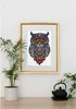 A framed owl picture hangs on a white wall above a wooden surface with a potted plant and a teapot. Náhled obrázku produktu