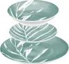 A stack of three teal-colored plates and bowls with white leaf patterns, presented against a white background. Anteprima dell’immagine prodotto