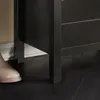 A close-up view of the bottom part of a dark-colored furniture piece, possibly a shoe cabinet or bench, with a beige boot in the foreground. Anteprima dell’immagine prodotto