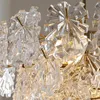 A close-up view of a chandelier with many clear, faceted glass elements and gold-colored metal accents. Anteprima dell’immagine prodotto