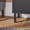 A close-up view of the legs of a black cabinet and a wooden floor. Produktbild-Vorschau