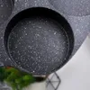 A close-up view of a speckled black frying pan with multiple circular indentations. Náhľad obrázku produktu