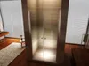 A modern bathroom with a glass shower enclosure, wooden floors, and blinds. Produktbild-Vorschau