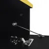 Close-up view of the interior of a black cabinet with a yellow top edge, showing a hinge and a gas strut mechanism. Produktbild-Vorschau