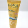 A close-up shot of a yellow tube of Uriage Bariésun tinted cream. Produktbild-Vorschau
