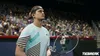 A tennis player stands on a court with a racket, looking up. The crowd is visible in the background. Produktbild-Vorschau