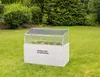 A raised garden bed with a transparent lid sits on a green lawn surrounded by bushes and trees. Anteprima dell’immagine prodotto