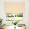 A roller blind is shown covering a window in a room, with a table and chairs in the foreground. Náhled obrázku produktu