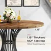 A close-up view of a round wooden dining table with a decorative metal base, featuring a floral arrangement and a bottle of wine. Text overlays provide product specifications. Podgląd zdjęcia produktu