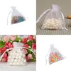 A collage of four images showing small white organza drawstring bags filled with various items like pearls and beads. Produktbild-Vorschau