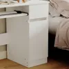 A close-up view of a white desk next to a bed. Podgląd zdjęcia produktu