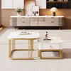 A modern living room scene featuring two marble-look coffee tables with gold accents, placed on a striped rug in front of a console table with decorative items and a lamp. Voir les images du produit