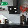 A modern kitchen scene featuring a black glass range hood mounted above a black induction cooktop. Decorative items like plants, cutting boards, and spices are visible on the countertop. Produktbild-Vorschau