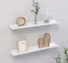 Two white shelves mounted on a light gray wall, decorated with home decor items. Produktbild-Vorschau