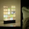 A Minecraft-themed lamp made of building blocks sits on a shelf next to a bed. Náhľad obrázku produktu