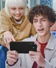 Two young people are looking at a smartphone held by one of them. Produktbild-Vorschau