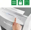 A hand is shown pressing a button on a white and gray paper shredder. There are also three green squares with icons and text above the shredder. Voir les images du produit