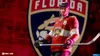 A hockey player in a Florida Panthers jersey stands in front of the team's logo. Produktbild-Vorschau