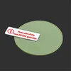 A green, circular object with a white sticker on it, set against a dark gray background. Anteprima dell’immagine prodotto