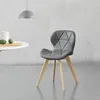 A gray dining chair with wooden legs is shown in a minimalist setting. Náhled obrázku produktu