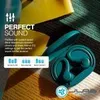 A close-up marketing shot of teal wireless earbuds in their charging case, with parts of yellow and green fabric in the background. Anteprima dell’immagine prodotto