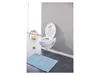 A white toilet with an integrated child seat is mounted on a gray wall in a bathroom. A blue bath mat is on the floor in front of the toilet. A small wooden stool with some items on it is to the left of the toilet. Produktbild-Vorschau